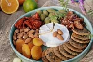 Delicious gourmet platter with cheese, almonds, olives, and dried fruits for a perfect brunch.